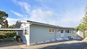 A single-story building with a gabled roof, a front porch, and a small attached garage.