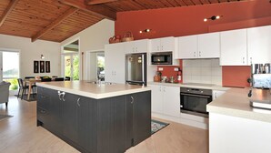 A modern kitchen with a large island, white cabinets, and stainless steel appliances.
