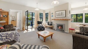 A spacious living room with a fireplace, a television, and a comfortable seating area.