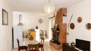 Ein gemütlicher Wohnraum mit Essbereich, einer Küche und einem Kamin.