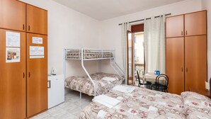 A bedroom with bunk beds, wooden wardrobes, a small table, and a chair. - Grotta di Rita (Turin)