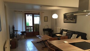 En moderne stue med et træspisebord, en sofa og en gulvlampe.