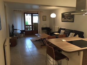Una sala moderna con una mesa de comedor de madera, un sofá y una lámpara de pie.