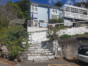 Un bâtiment situé en bord de mer, avec une enseigne indiquant « City Beach » et un escalier menant à l’entrée.