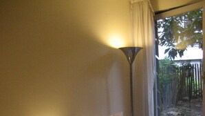 A hotel room with two beds, a nightstand, a lamp, and a view of the outdoors. - Spacious,  quiet family flat with terrace and parking in the 18th Montmatre (Paris)