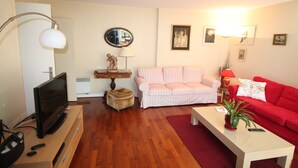 A living room with a television, sofa, and coffee table. - Spacious,  quiet family flat with terrace and parking in the 18th Montmatre (Paris)