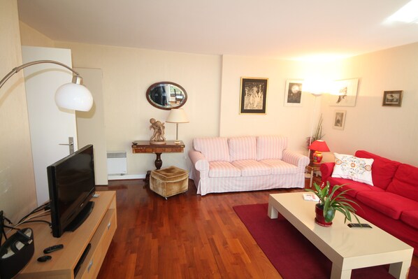 A living room with a television, sofa, and coffee table.