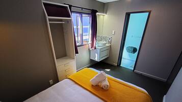 A hotel room with a bed, a bathroom, and a closet.