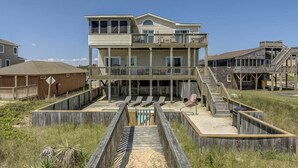 A multi-story beachfront building with a balcony, a pool, and a wooden deck. - Sandfiddler | Oceanfront | Dog Friendly, Private Pool, Hot Tub | Nags Head (Nags Head)