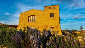 Un edificio de ladrillo amarillo con una ventana grande y otra más pequeña en un lateral.