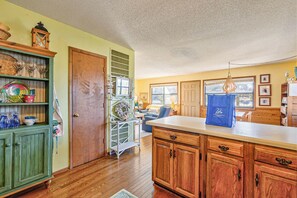 A kitchen with wooden cabinets, a countertop, and a blue bag on the counter.