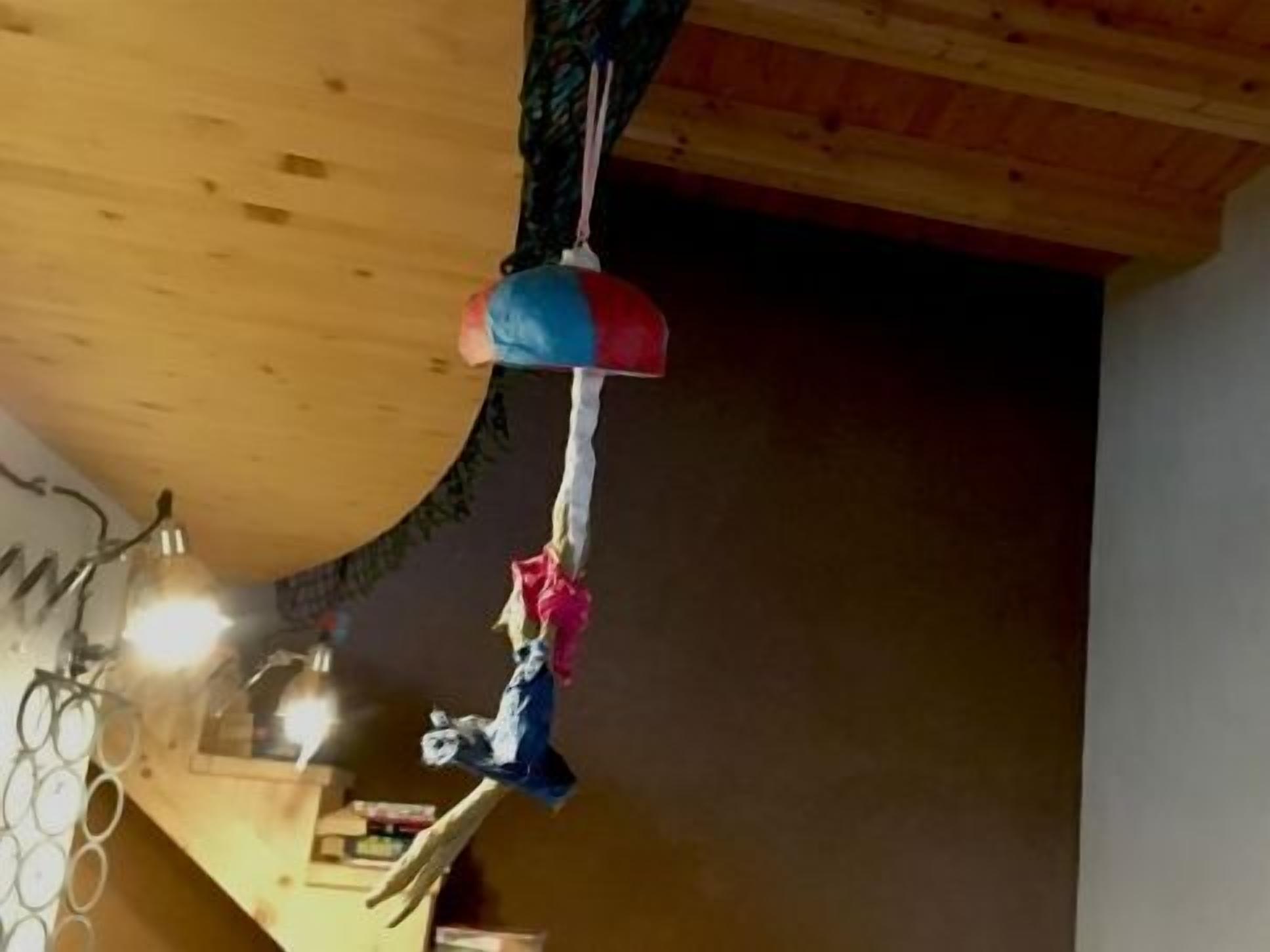 Una habitaci ón con techo de madera, un objeto colgante y una lámpara visible.