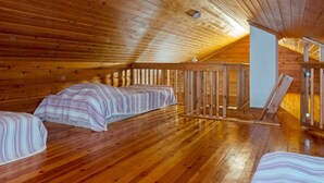 A cozy attic bedroom with wooden floors and sloped ceilings.
