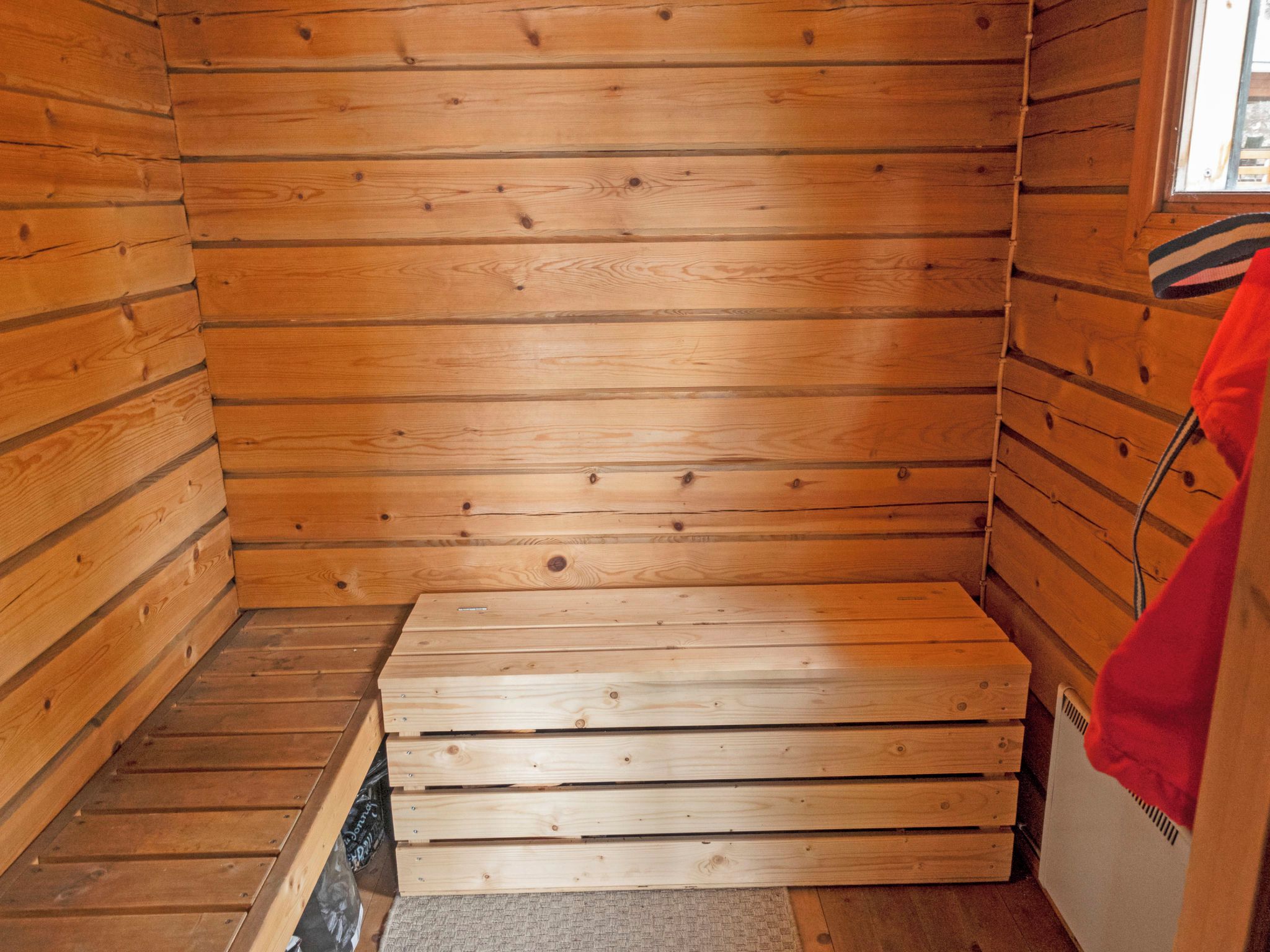 Un sauna avec des murs en bois et un banc.