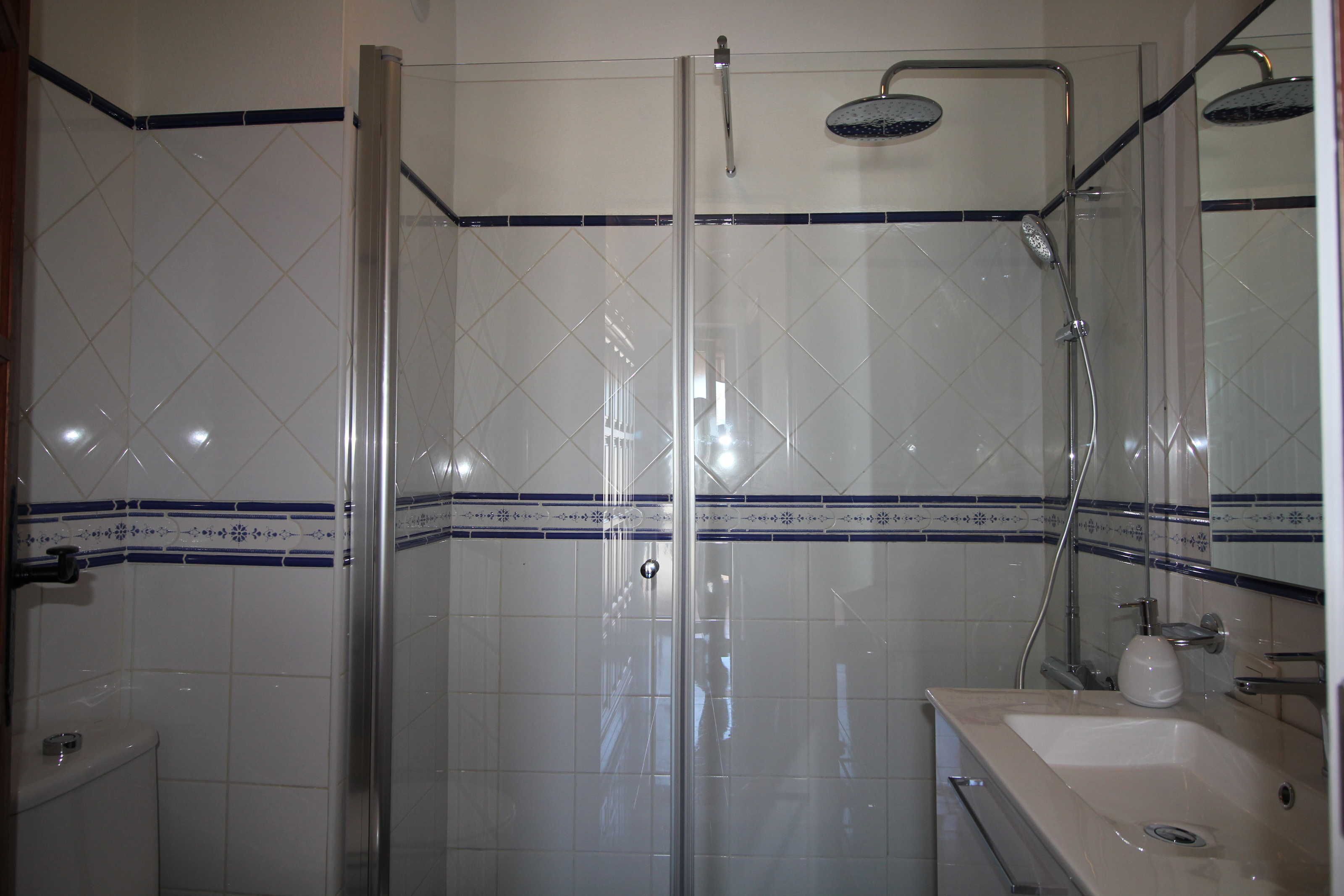 Ein Badezimmer mit Duschkabine, Waschbecken und Toilette.