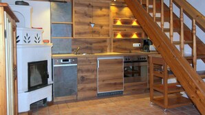 Une cuisine moderne avec des meubles en bois, un four encastré et un escalier en bois.