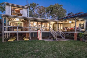 A two-story house with a covered porch, a staircase, and a garage. - Villa Belza - Lakeside cottage near Angourie beaches (Wooloweyah)