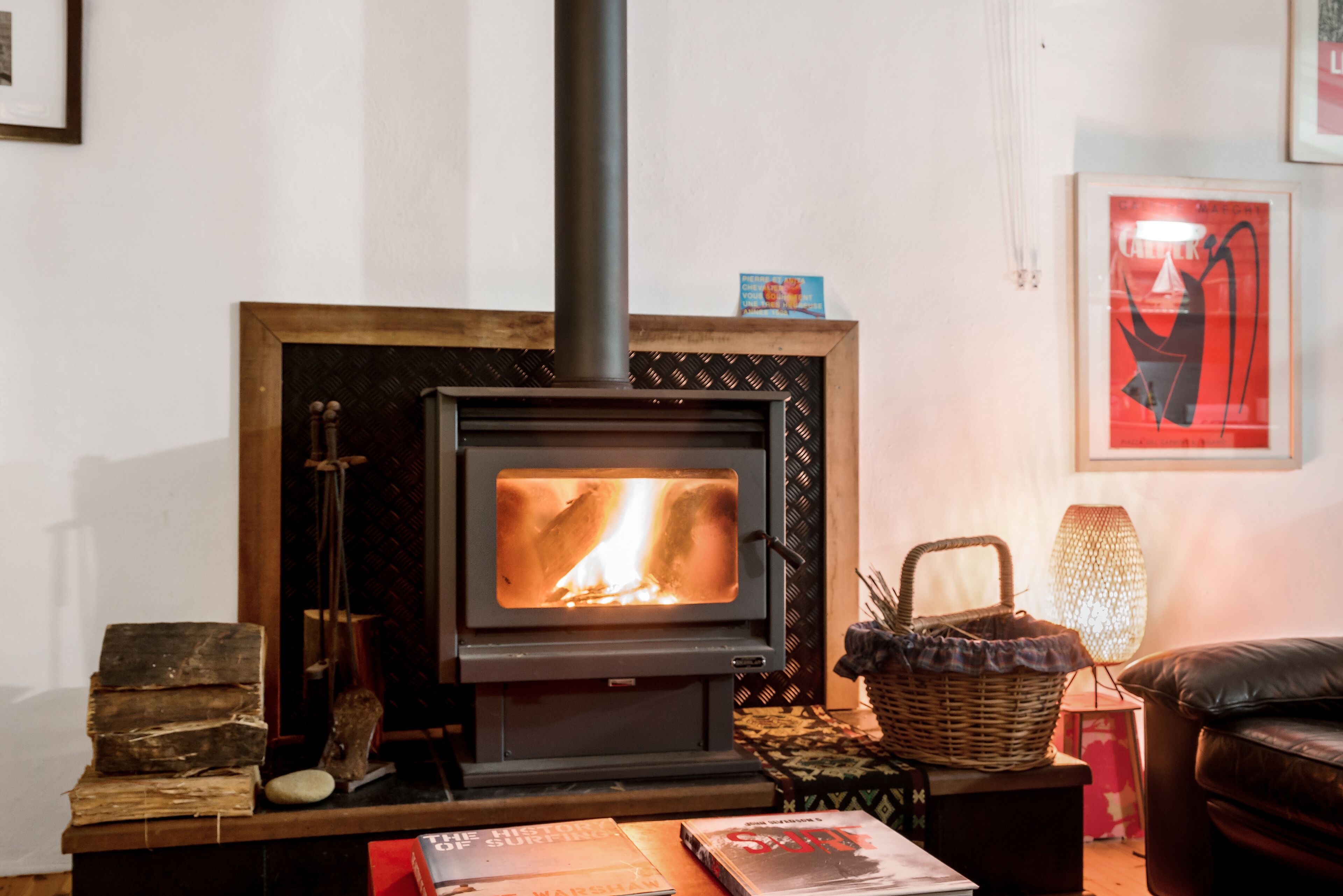 A cozy room with a wood-burning stove, a bookshelf, and a comfortable seating area.