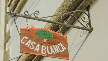 A wooden sign with the text "CASA BLANCA" hanging from a metal bracket.