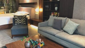 A modern living room with a sofa, armchair, and coffee table. - Wu Zhou City Ai Zhuke Shan Hai Apartment (Wuzhou)