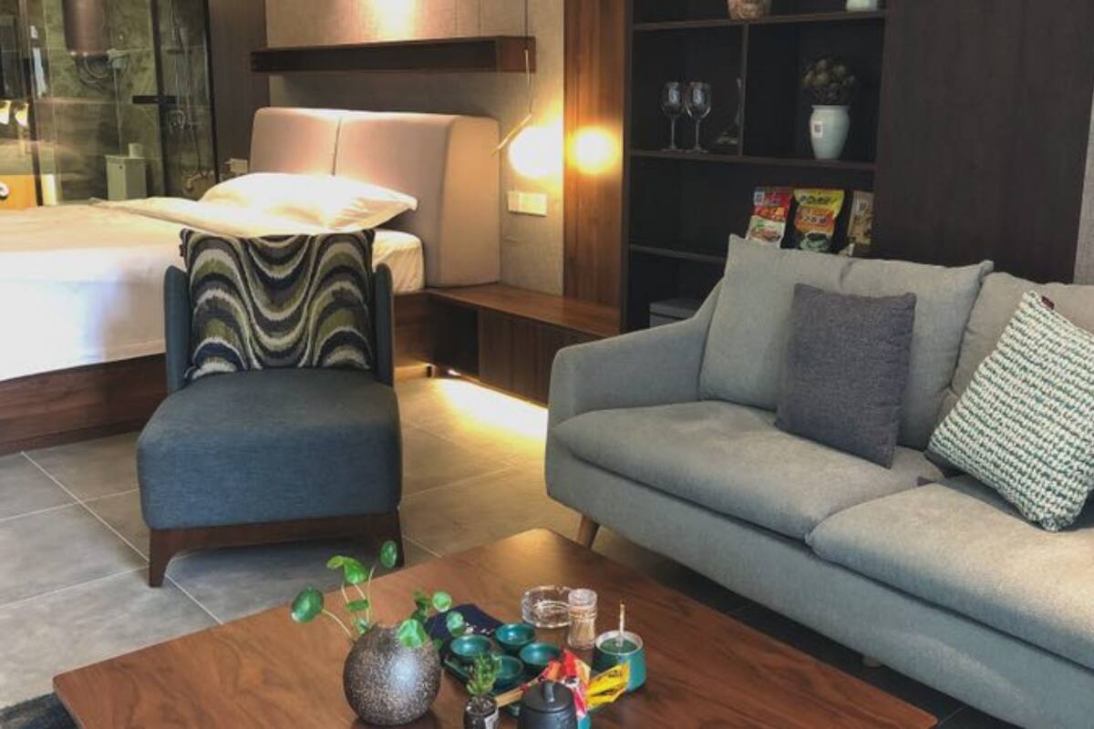 Un salon moderne avec un canapé, un fauteuil et une table basse.