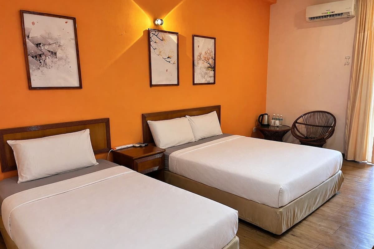 A hotel room with two beds, a nightstand, a chair, and artwork on the wall.