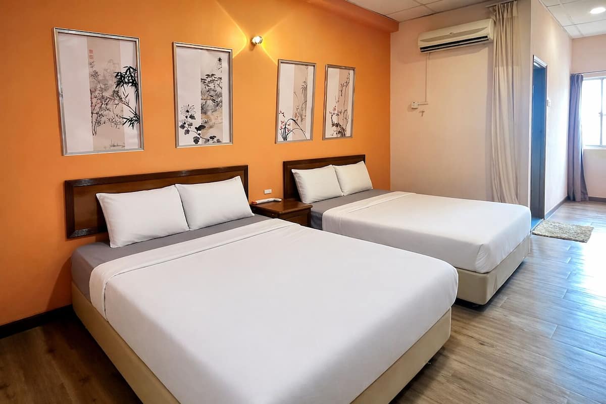 A hotel room with two beds, a wooden headboard, a wall-mounted air conditioner, and framed artwork.