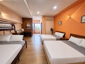 A hotel room with two single beds, a desk, a chair, an air conditioning unit, and a view of the outdoors. - Heng Ann Guest House (Malacca City)