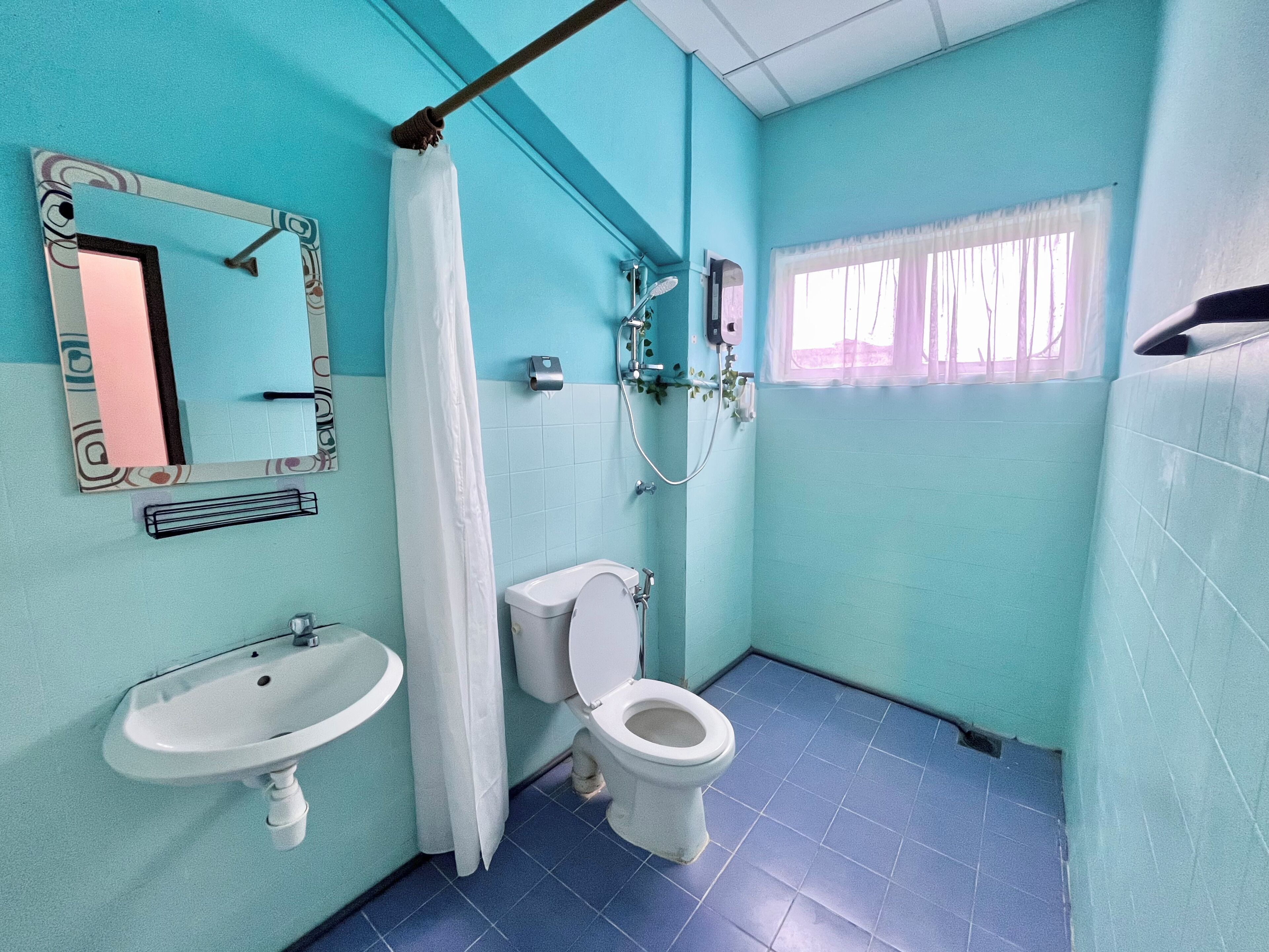 Ein Badezimmer mit Toilette, Waschbecken, Dusche und Spiegel.