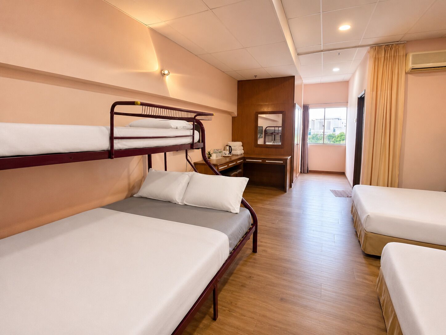 Ett hotellrum med våningssängar, ett skrivbord, en stol och utsikt över omgivningarna.