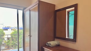Un baño con tocador de madera, un espejo y vista a un edificio azul.