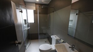 A modern bathroom with a glass shower enclosure, a toilet, and a sink with a mirror. - Bituin sa Tala (Orani)