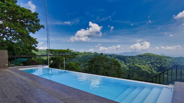 A swimming pool with a view of a forested mountain range. - Bituin sa Tala (Orani)
