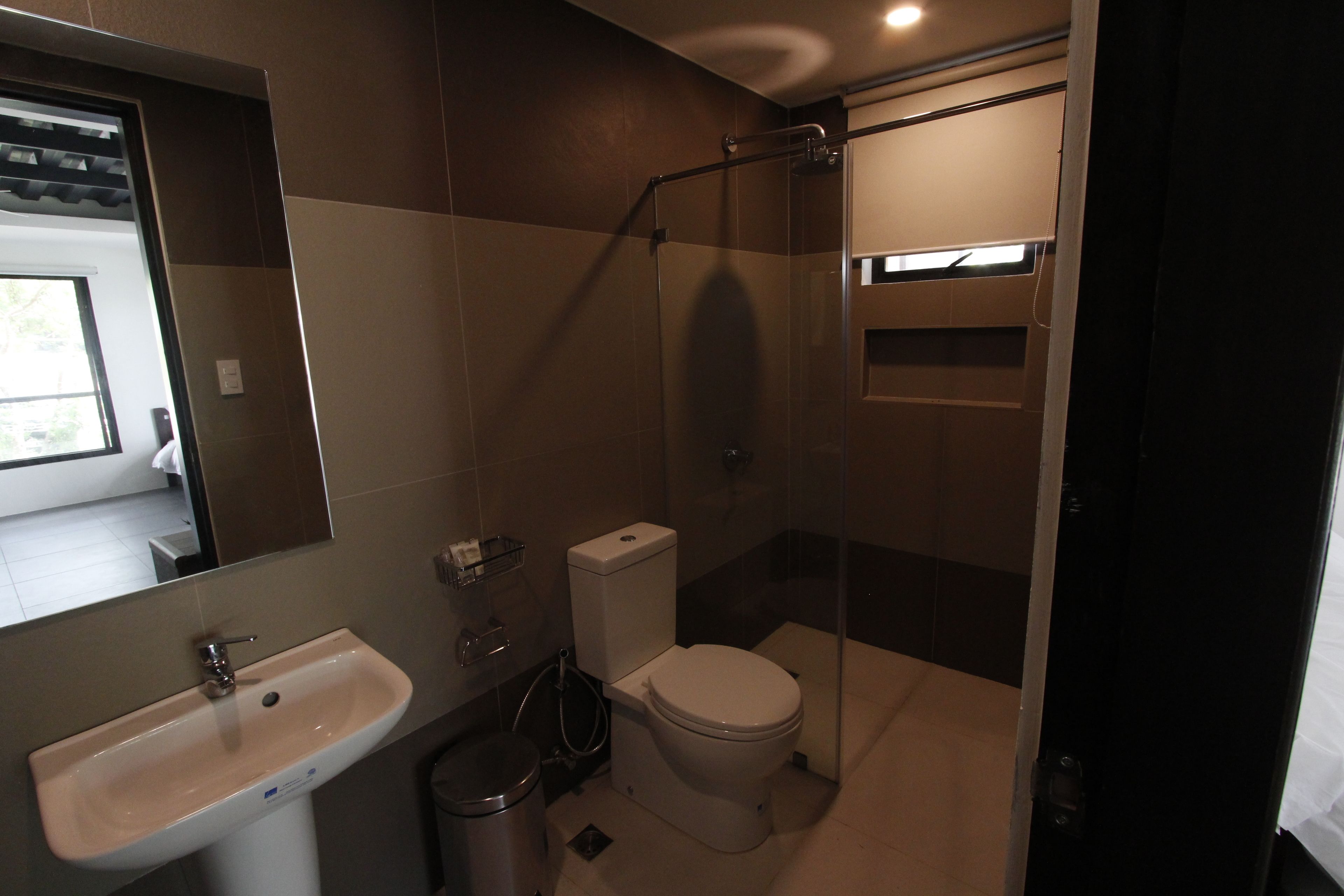 A modern bathroom with a sink, toilet, and glass shower enclosure.