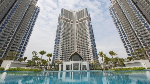 Ein Hochhotel mit einem zentralen Atrium und einem Schwimmbad im Vordergrund.