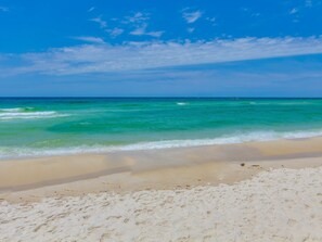 Ein Strand mit klarem türkisblauem Wasser und einem Sandufer.