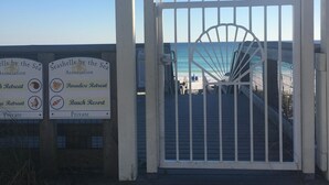 Ein verschlossenes Tor mit freiem Blick auf Strand und Meer.