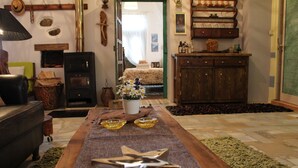 A cozy living room with a fireplace, a sofa, a coffee table, and a dining table with a runner.