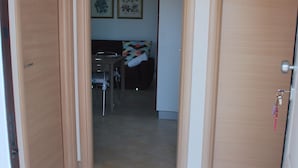 A bathroom with a tiled floor, a wooden vanity, a mirror, and a towel rack. - Vacation in the House of Dreams (Portoscuso)