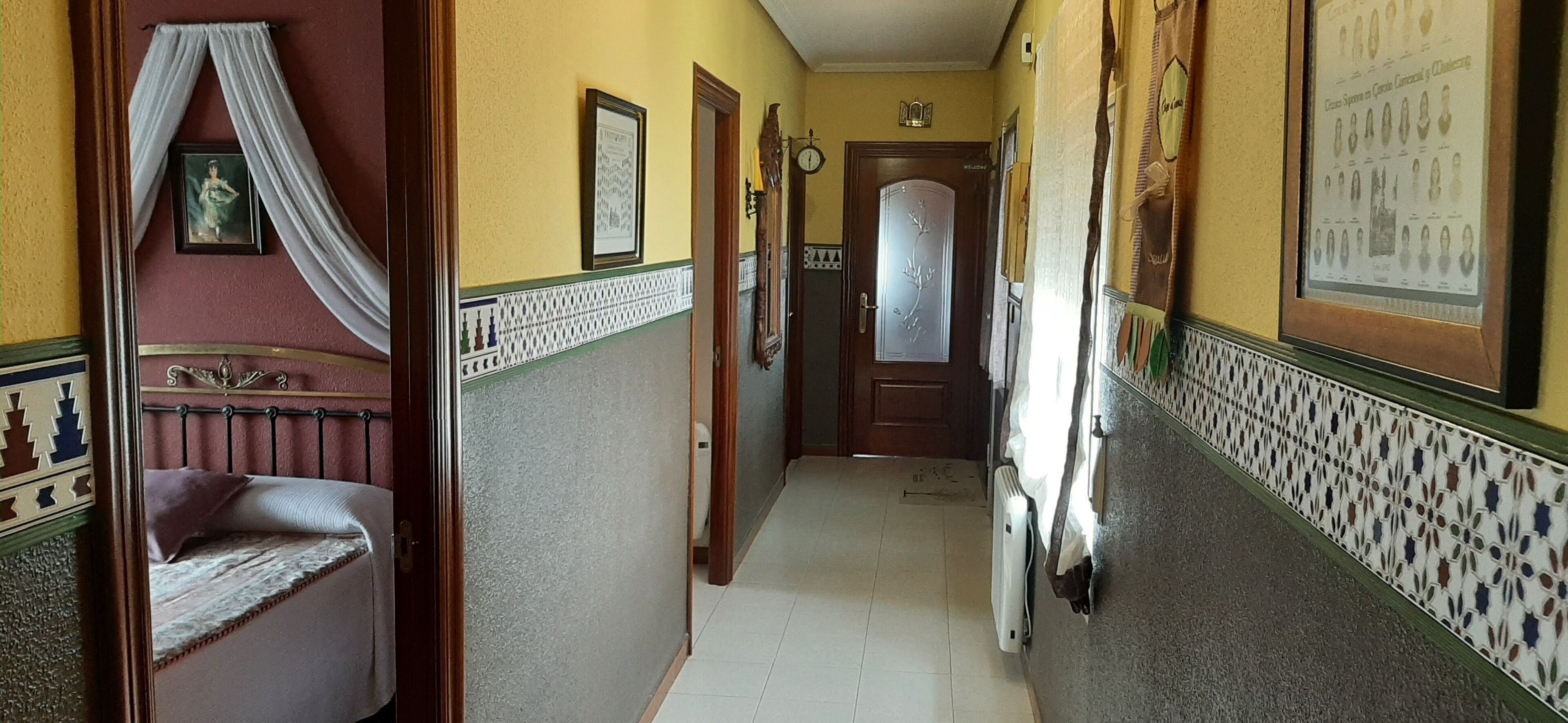 A hallway with a bed, a door, and a radiator.