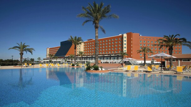 A hotel with a large pool, palm trees, and a clear blue sky. - Marriott Park hotel Rome (Lazio)
