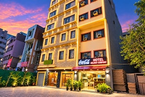 A hotel with a Coca-Cola sign, multiple floors, and a brick facade. - Hotel Holiday Comfort - 800 mts from Jallianwala Bagh, Amritsar (Amritsar)