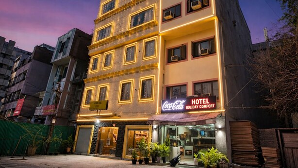 A multi-story hotel with a Coca-Cola sign, featuring a modern facade and a visible entrance. - Hotel Holiday Comfort - 800 mts from Jallianwala Bagh, Amritsar (Amritsar)