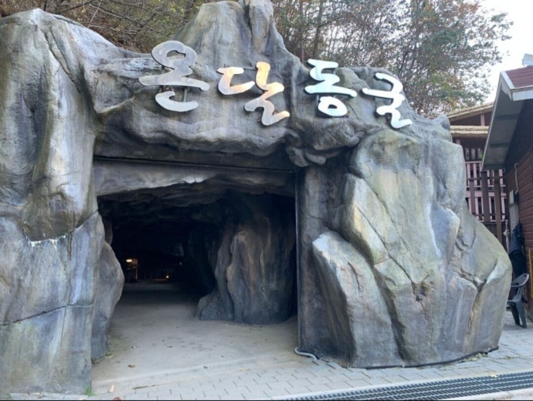 A large rock structure with a sign above it.