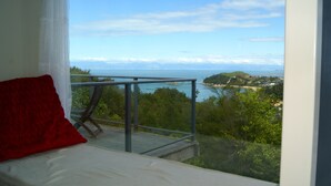 Un balcón con vista despejada al mar y una isla distante.