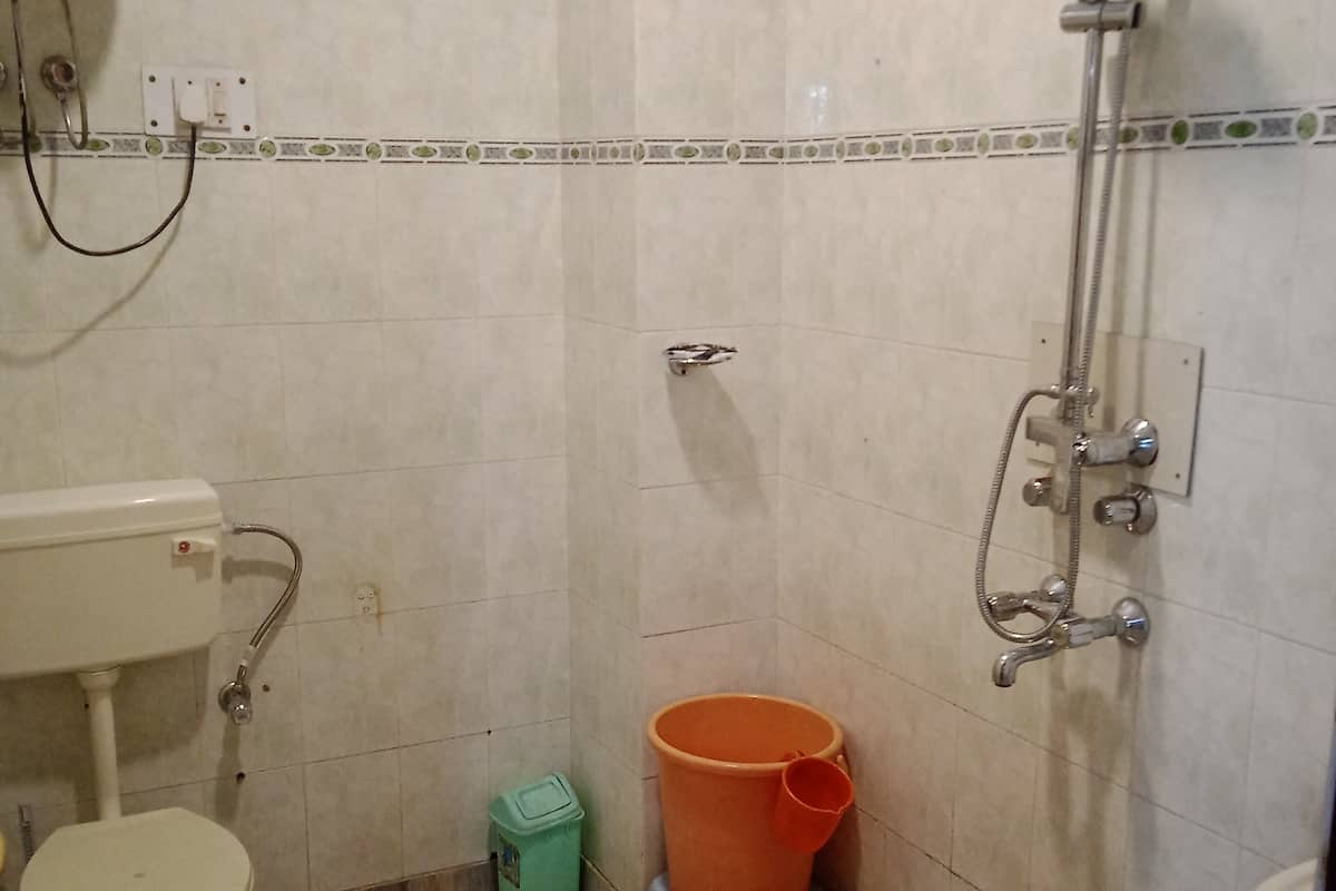 Un baño pequeño con inodoro, lavabo, ducha y suelo de mármol.