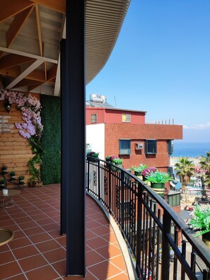 Habitación cuádruple familiar, balcón, vista parcial al océano | Vista del balcón