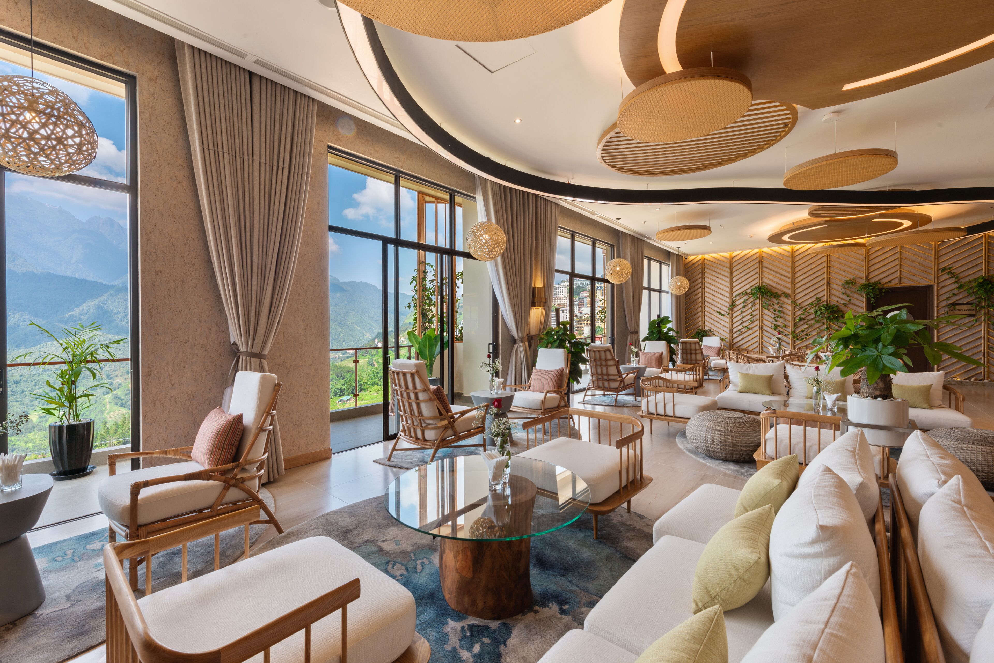 A spacious living area with large windows, comfortable seating, and a modern design.