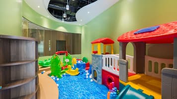 A children's play area with a slide, climbing structures, and a ball pit.