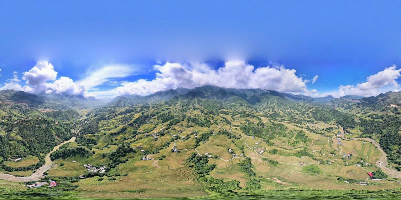 Una vista panorámica de un paisaje montañoso con campos en terrazas y casas dispersas.